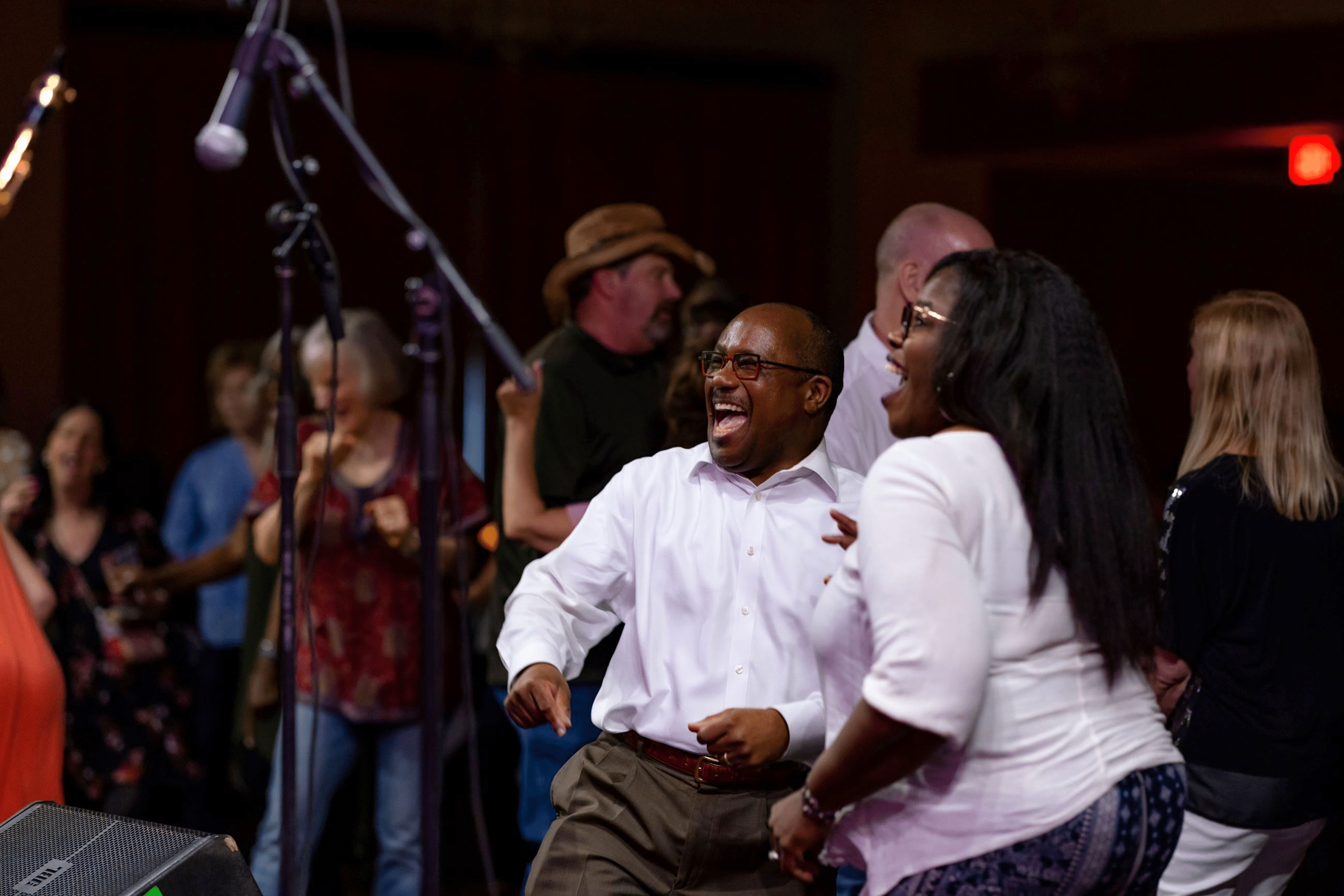 Two people in white shirts dancing at a concert.