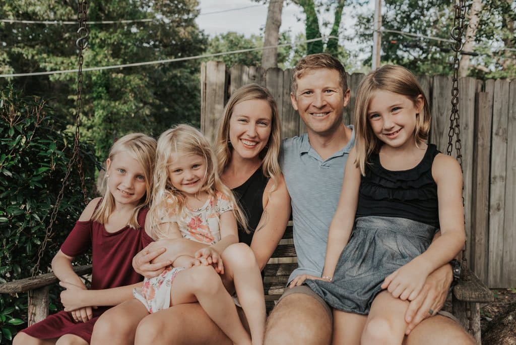 Attractive, smiling family sitting together on a swing