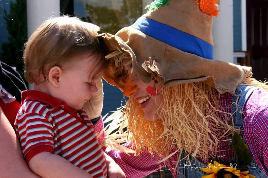 small boy with person dressed up as a scarecrow