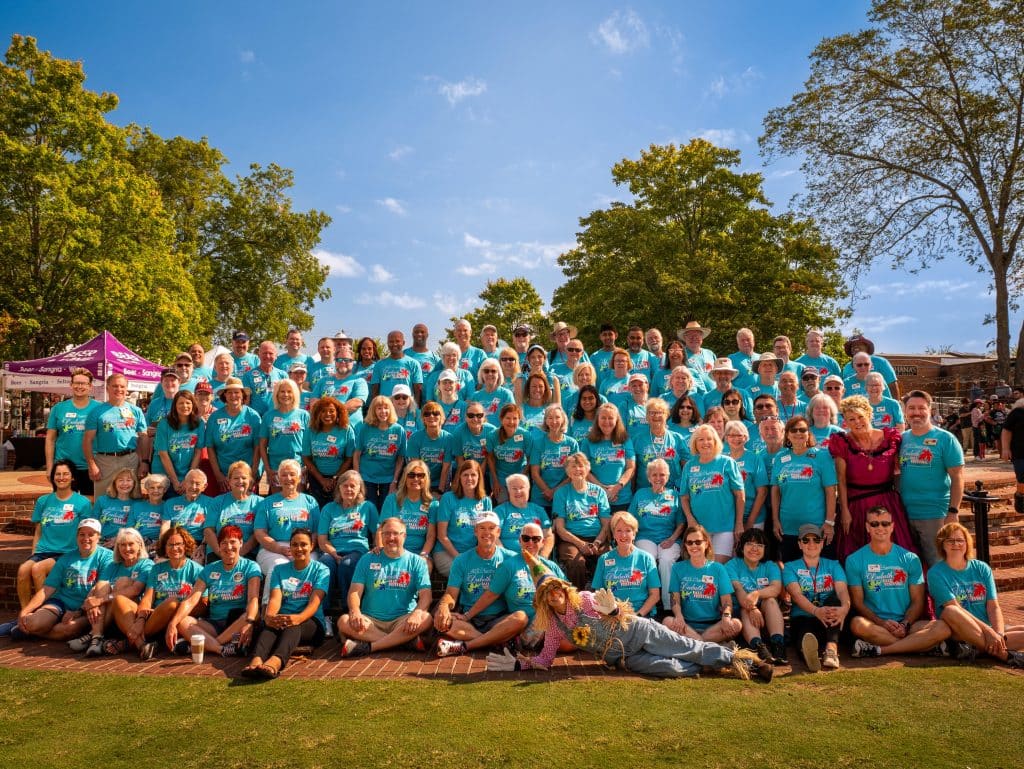 Group of people wearing matching shirts posing for photo