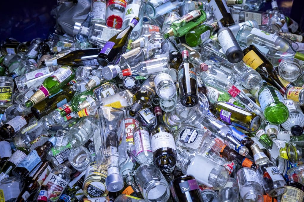 A large pile of empty glass bottles for recycling