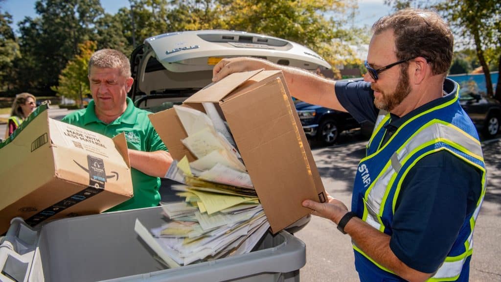 Two people recycling paper