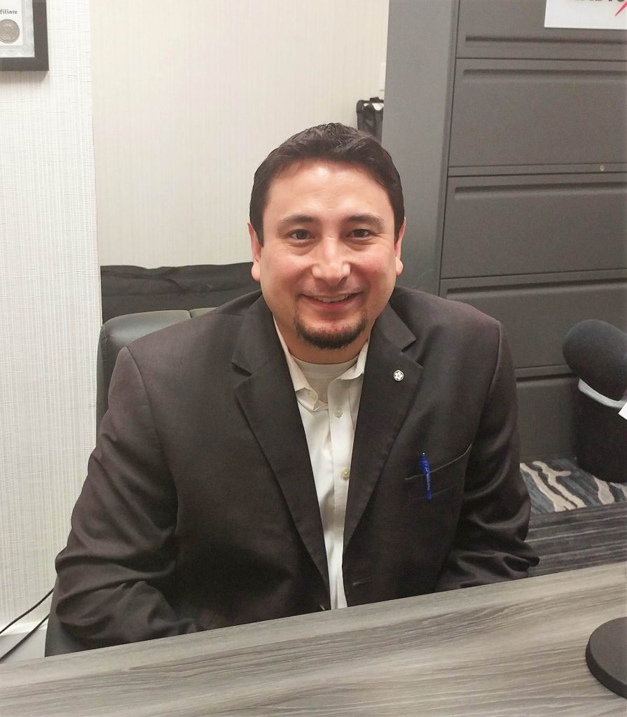 Smiling man in casual suit sitting at desk