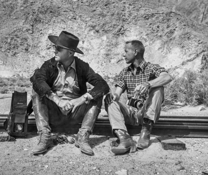 Two men sitting on railroad tracks