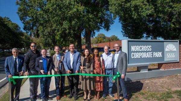 Group of people standing outside at a ribbon-cutting ceremony for the completion of the Oakbrook Parkway sidewalk project