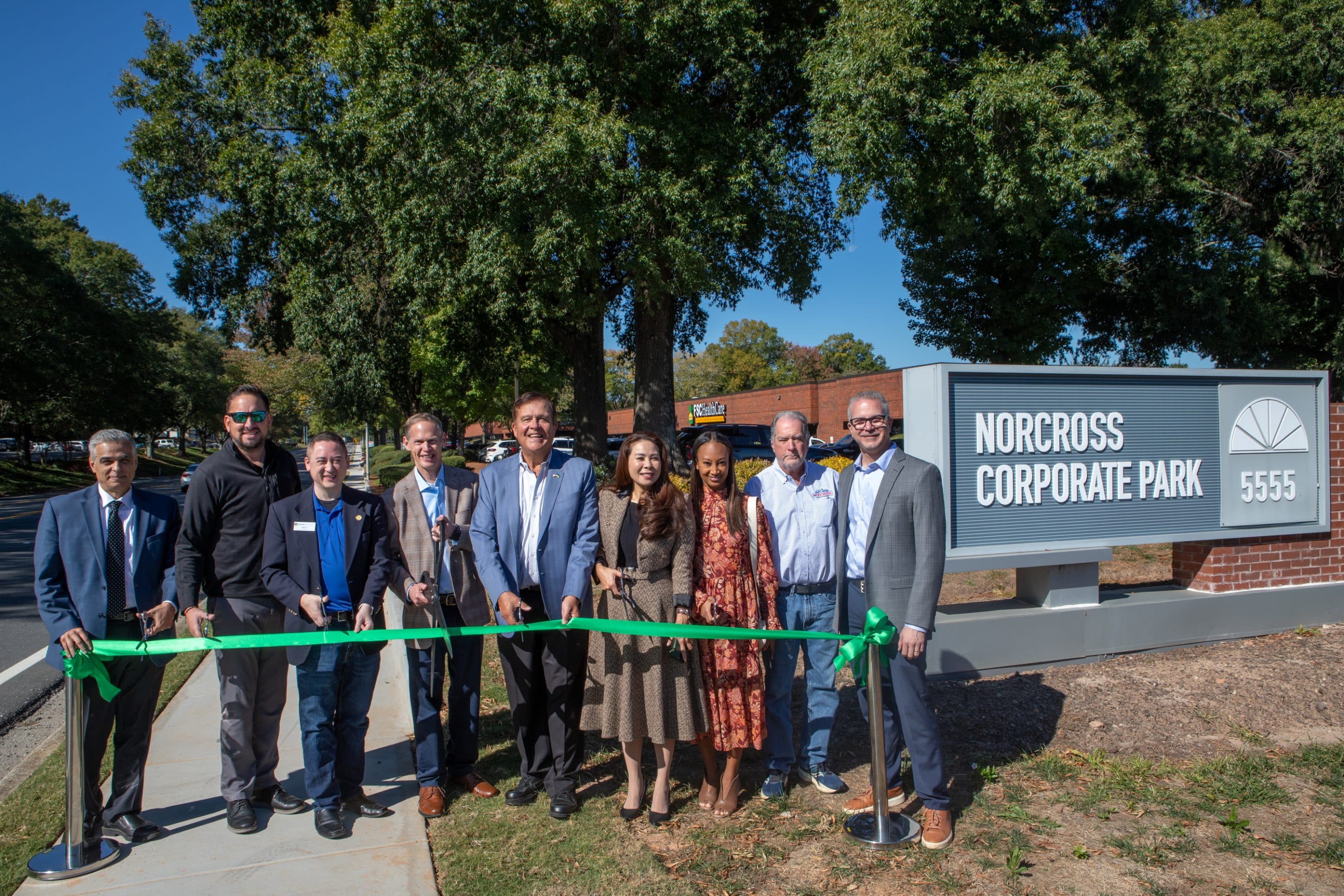 Group of people standing outside at a ribbon-cutting ceremony for the completion of the Oakbrook Parkway sidewalk project