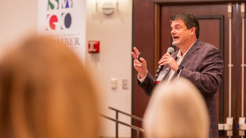 Man speaking in front of an audience at a Southwest Gwinnett Chamber of Commerce meeting