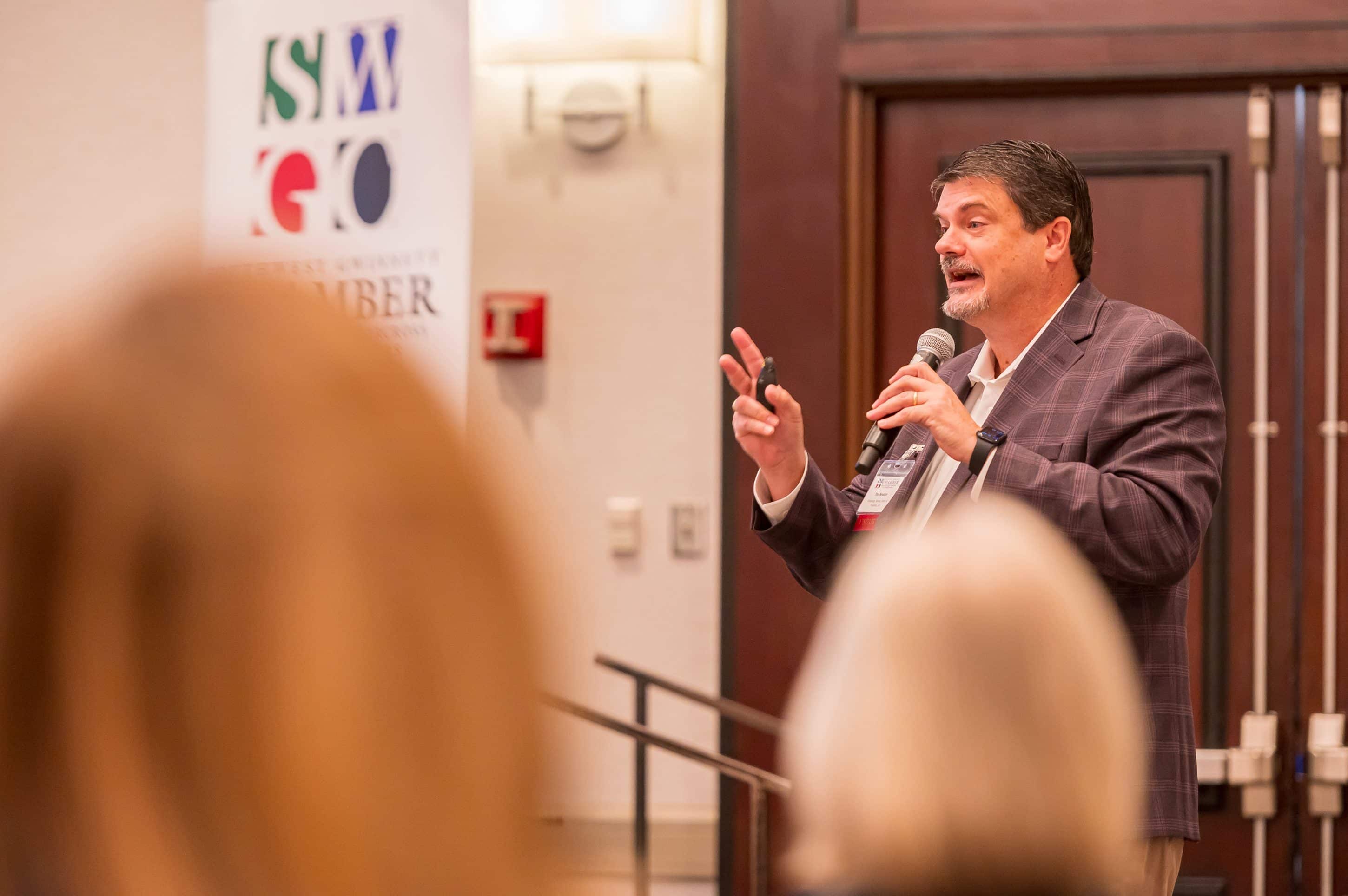 Man speaking in front of an audience at a Southwest Gwinnett Chamber of Commerce meeting