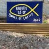 blue and yellow sign with the Christian fish symbol and the name Duluth Co-op