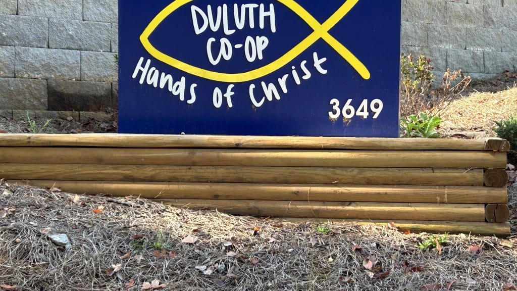 blue and yellow sign with the Christian fish symbol and the name Duluth Co-op