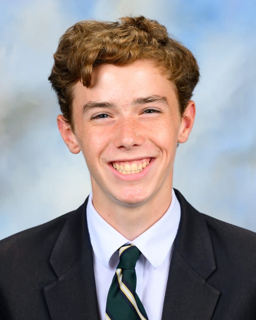 School photo of a young white male with a large smile, wearing a suit and tie.