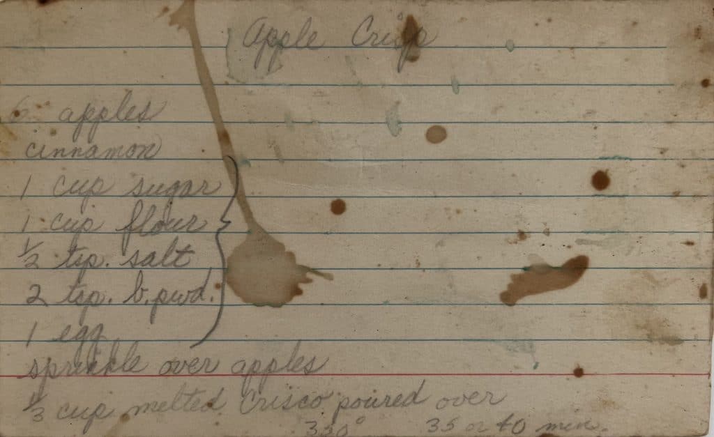 Old, handwritten recipe for Apple Crisp on a worn, stained index card