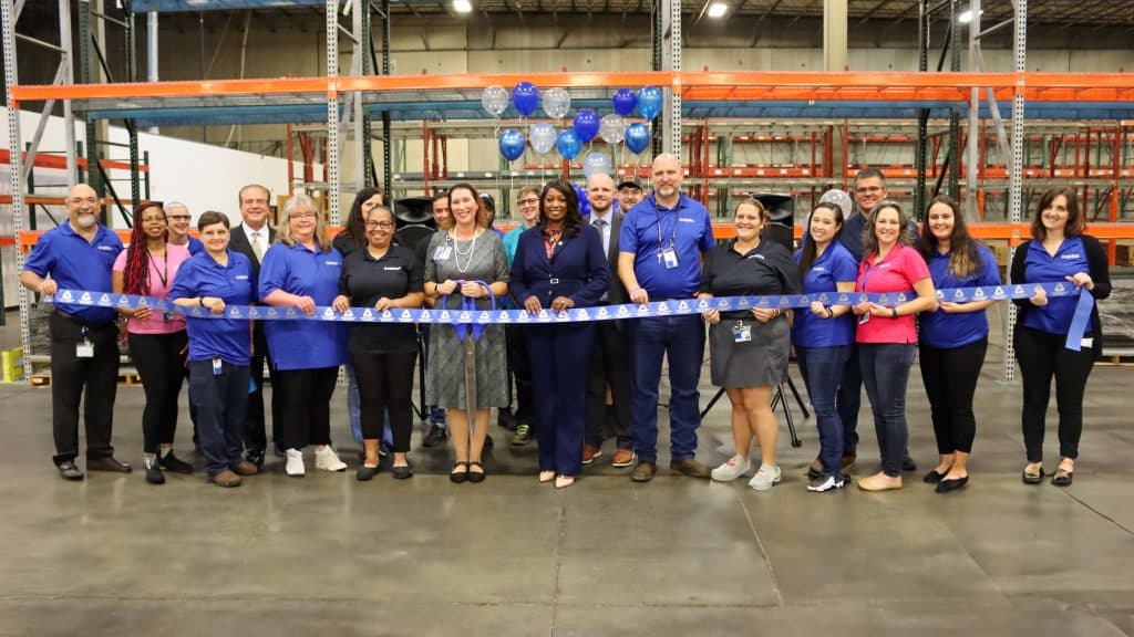 Group of people in a warehouse building at a ribbon cutting ceremony