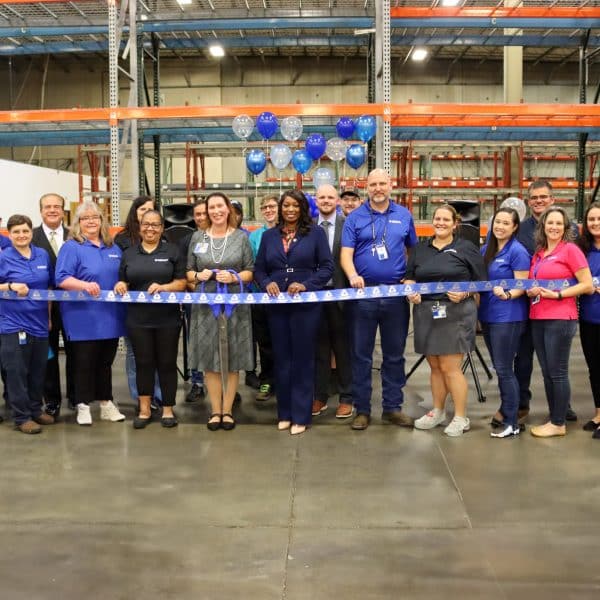 Group of people in a warehouse building at a ribbon cutting ceremony