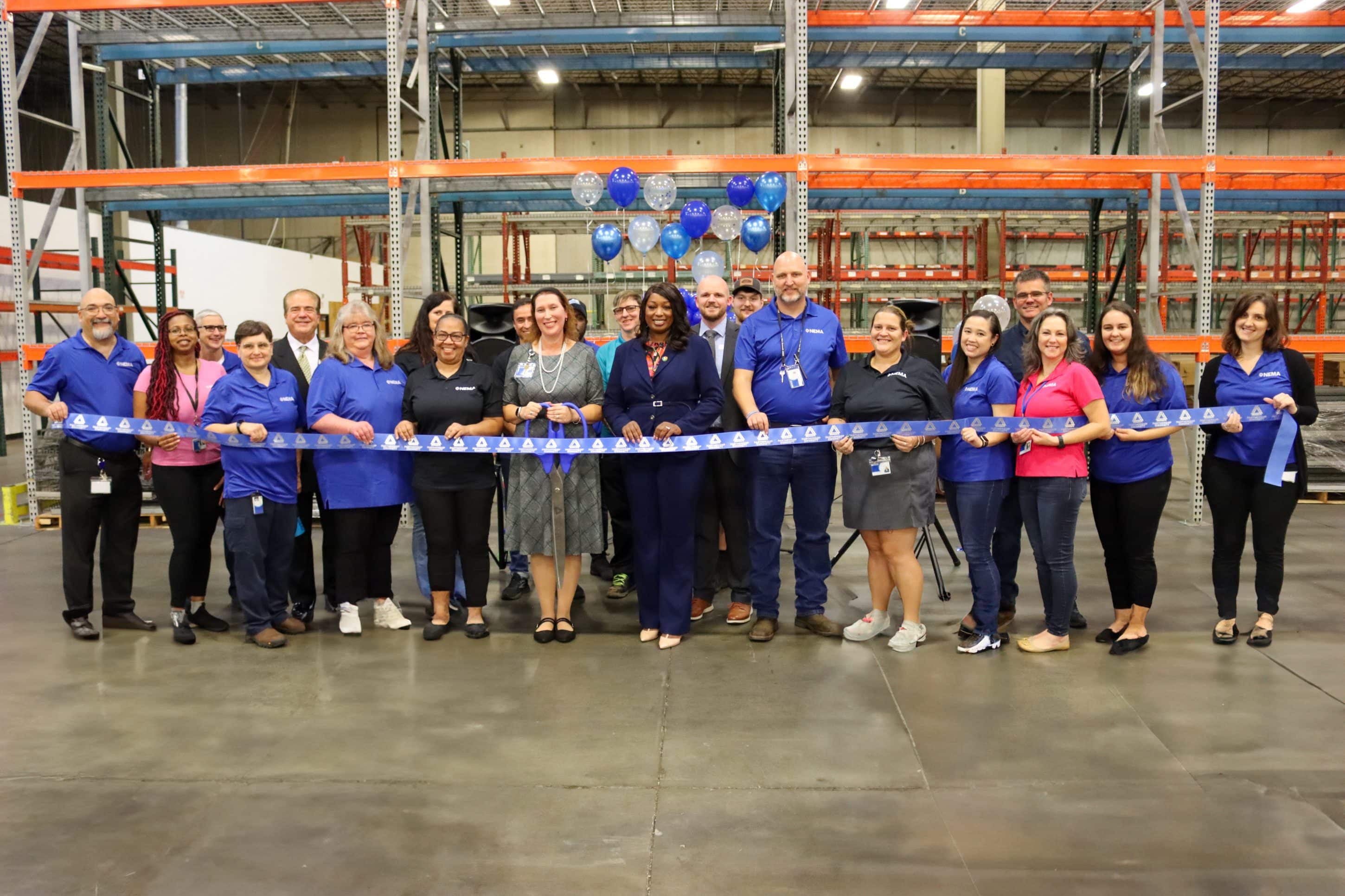 Group of people in a warehouse building at a ribbon cutting ceremony