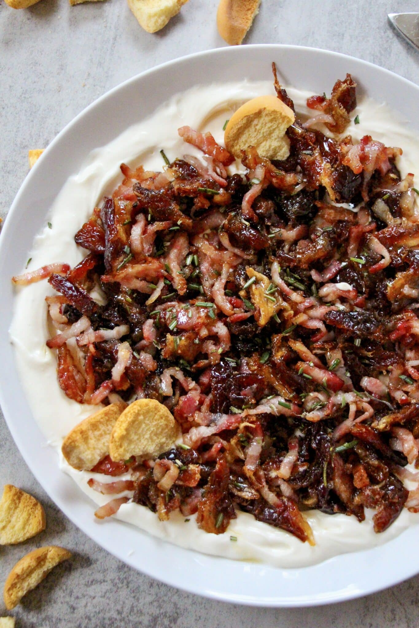 Serving bowl of whipped cheese topped with a warm bacon and dates mixture