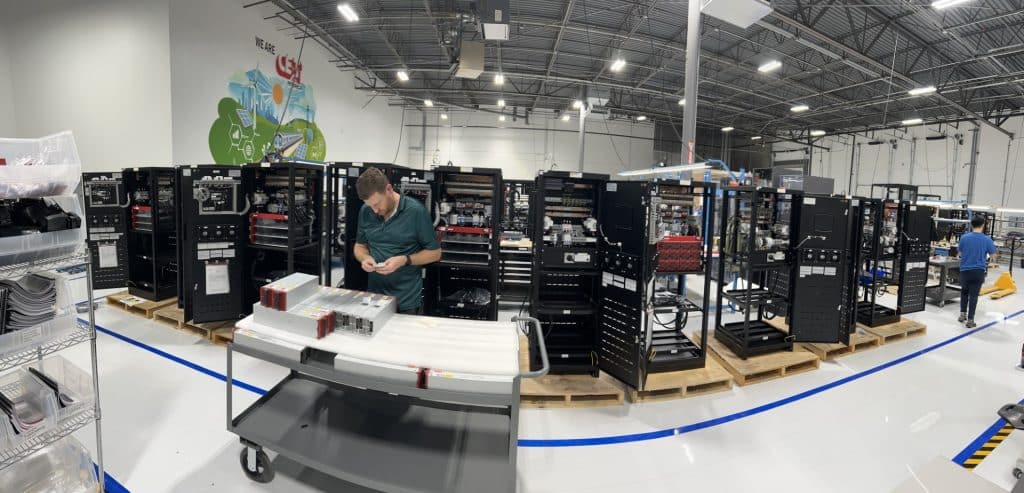 panoramic shot of the interior of a very clean, state-of-the-art manufacturing facility with equipment and people working