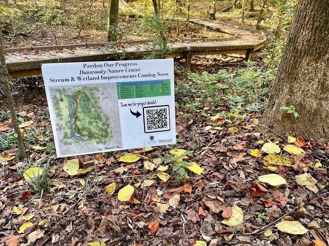 Small sign on the ground at a nature center informing about improvements being made to the park