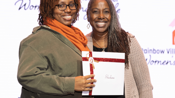 One woman awarding a prize to another woman at a community event