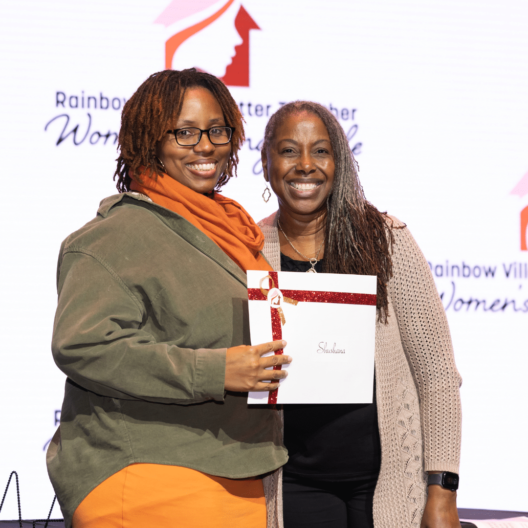 One woman awarding a prize to another woman at a community event