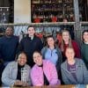 Small group of people from the Explore Gwinnett staff, sitting outside smiling for the photo