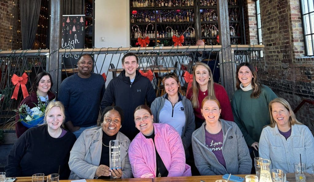 Small group of people from the Explore Gwinnett staff, sitting outside smiling for the photo