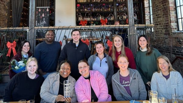 Small group of people from the Explore Gwinnett staff, sitting outside smiling for the photo