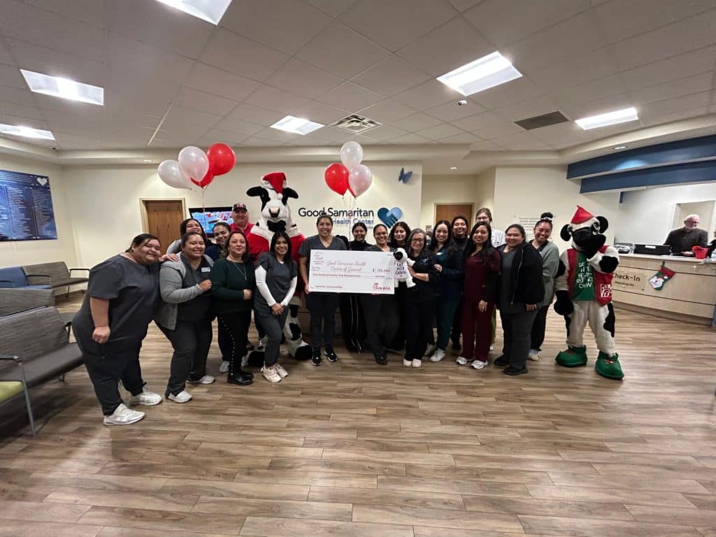 A group of people from Good Samaritan Gwinnett accepting a $125,000 donation grant from Chick-fil-A. There are red and white balloons in the background.