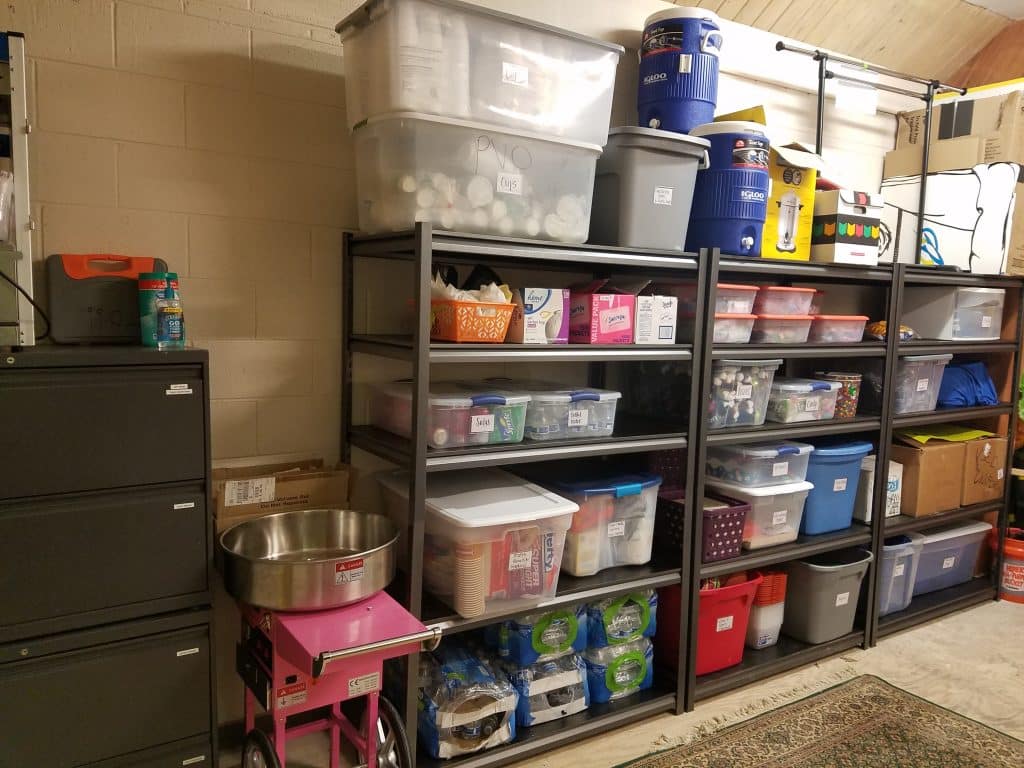 An organized storage room with shelves and cabinets and everything in labeled boxes and bins.