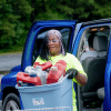 Volunteer hauling a bin of household hazardous waste from a participants vehicle at a HHW drop off event in Gwinnett County.