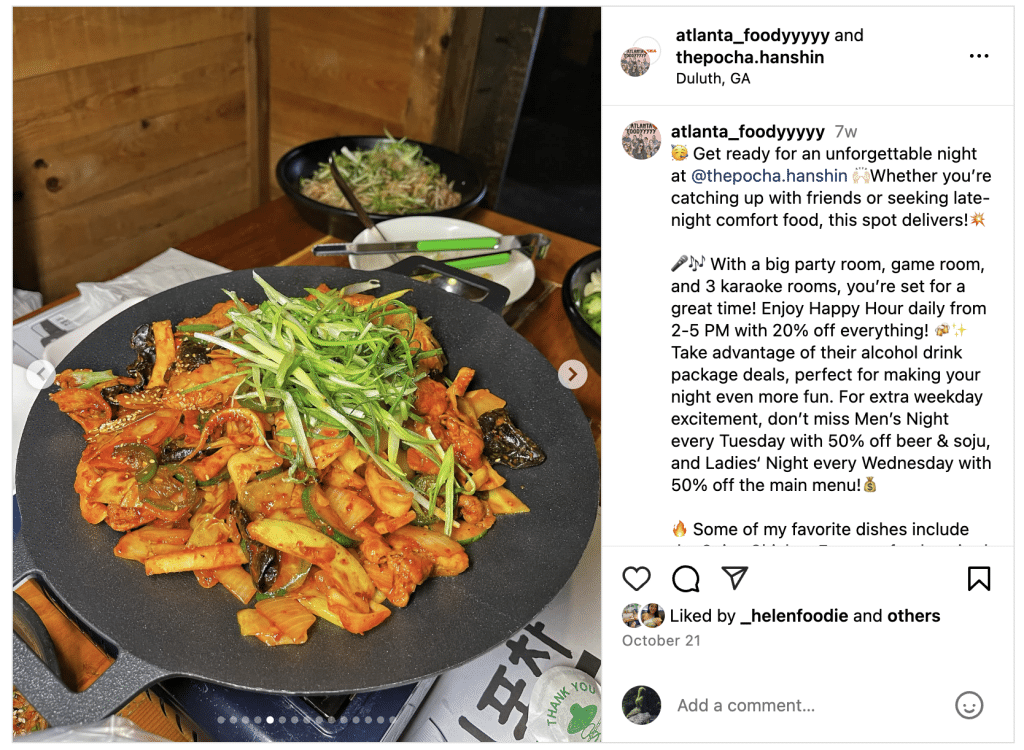 A platter of food served up on a black plate with small side dishes beside it at a Korean restaurant in Duluth, GA.