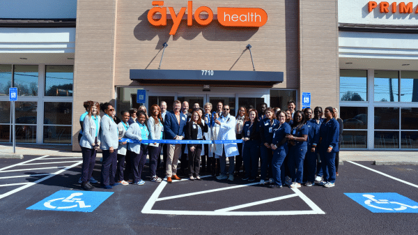 Group of people in a parking lot at a ribbon cutting for Aylo Health in Suwanee, GA.