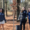 Three young women in a wooded area planting trees with City of Dunwoody on MLK Day of Service 2025.