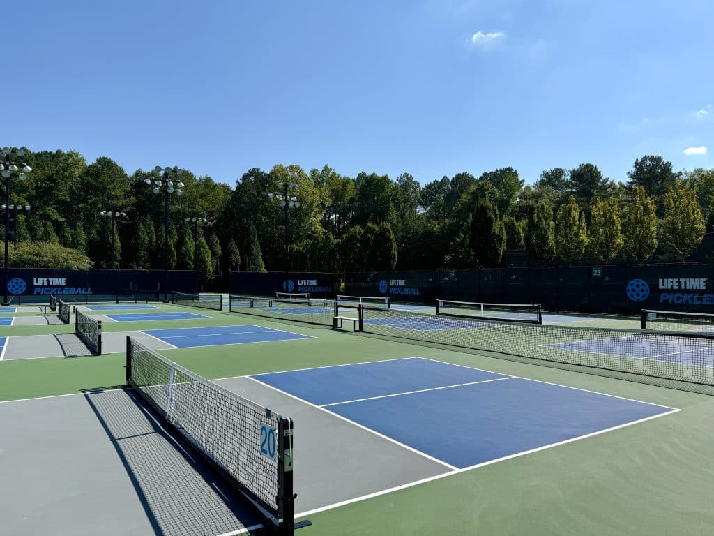 Outdoor pickleball courts with trees in the background