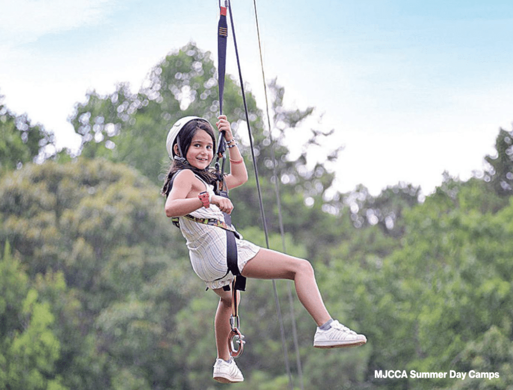 Young girl on a zipline at a summer camp 