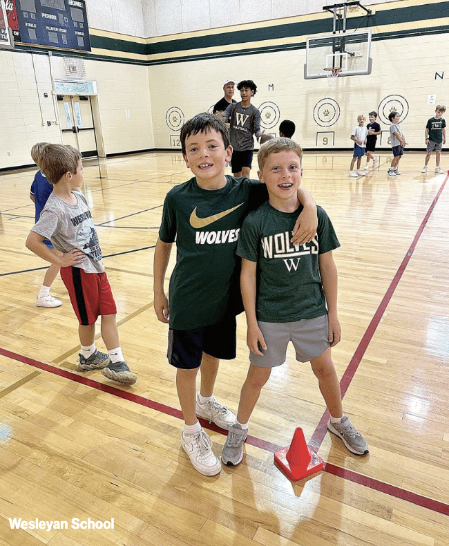 Kids on an indoor basketball court at Wesleyan School during summer camp