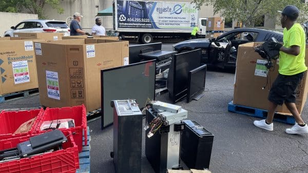 Electronics recycling event with boxes and electronics items filling up a parking lot.