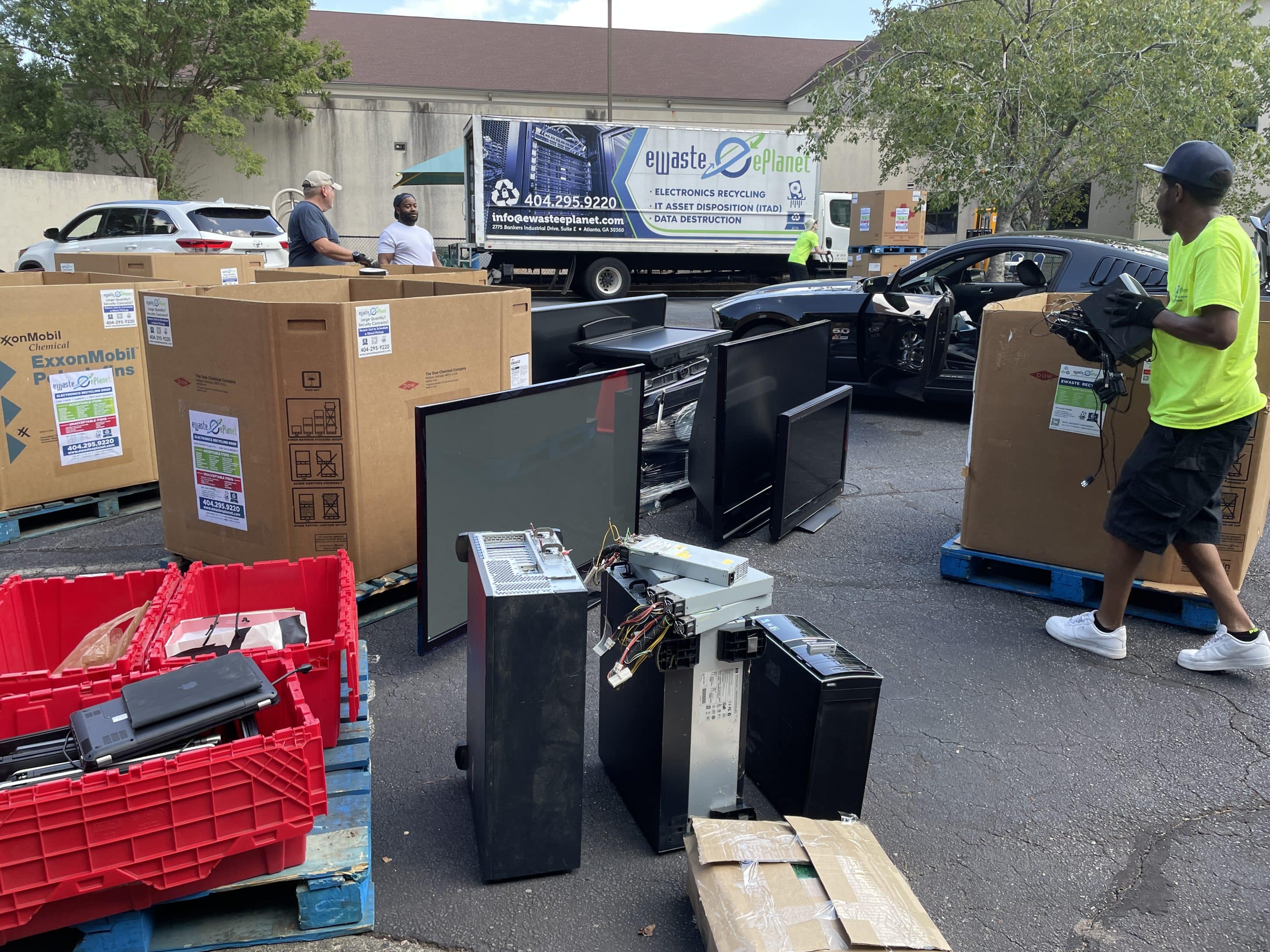 Electronics recycling event with boxes and electronics items filling up a parking lot.