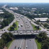 Aerial view of the 85 Gwinnett County corridor with highway, overpasses, cars, buildings and trees.