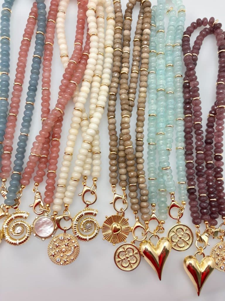 A collection of different colored beaded necklaces and charms