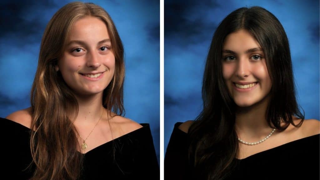 Senior photos of two female Norcross High School students. The one on the left has long blonde hair, parted in the middle. The one on the right has long black hair, parted in the middle. Both are wearing black, off-the-shoulder tops and have blue backgrounds behind them.