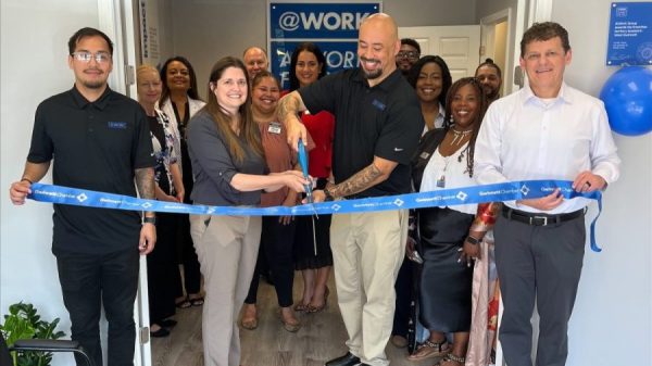 A group of people cutting a blue ribbon at the opening of their new business in Duluth, GA